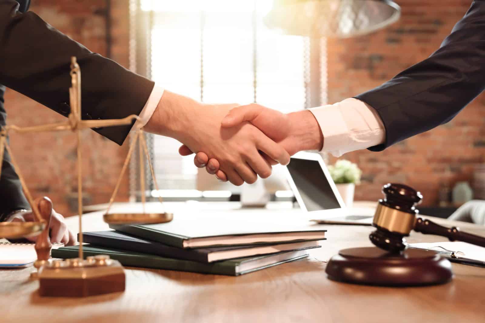 A personal injury attorney in Odessa, Texas, shakes hands and agrees to take on a case with a client.