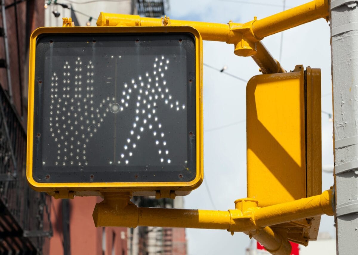 A close-up of a pedestrian traffic light showing the "walk" symbol illuminated.